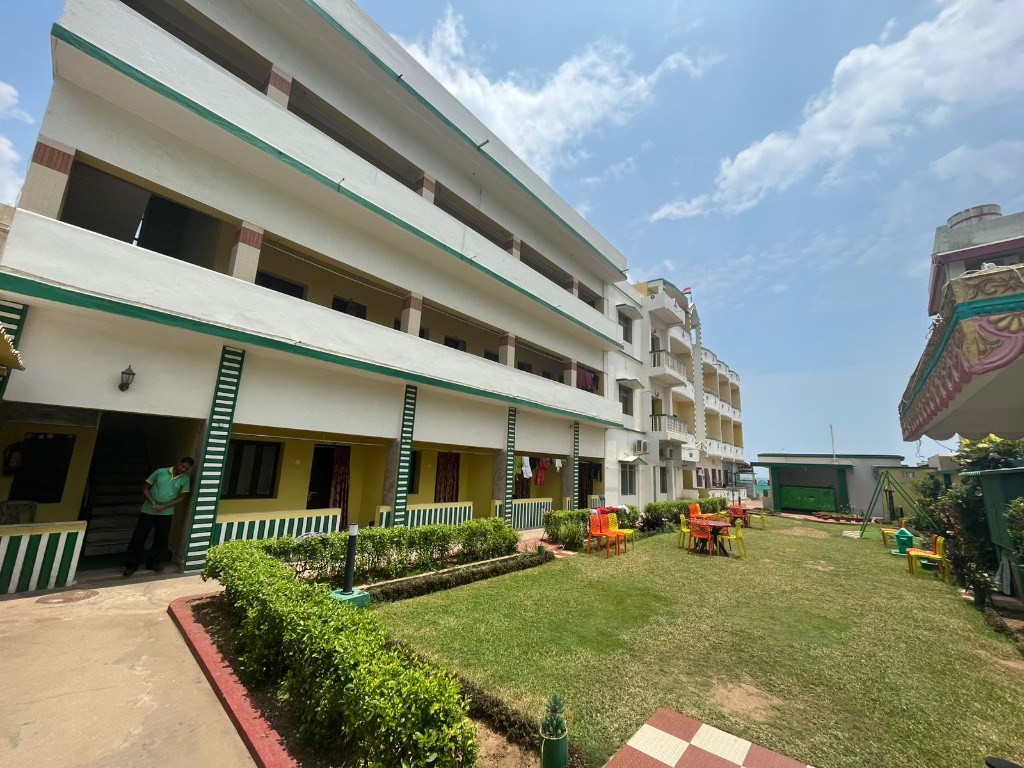 Krusti Resort facade and courtyard lawn on a sunny day in Puri